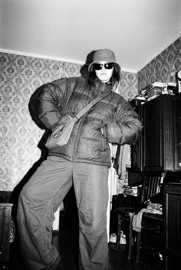 Bad pola: full-length shot in oversized coat, sunglasses and flash